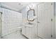 Bathroom features a white vanity, white wainscoting, tile floors, and a shower/tub with white curtain at 1904 Rosewood Ln, Woodstock, GA 30189