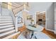 Spacious foyer featuring hardwood floors, a staircase, a round table with decor, and an open doorway to another room at 1904 Rosewood Ln, Woodstock, GA 30189