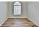 An empty bedroom with hardwood floors and a window that provides natural light at 3535 Southmont Ct, Cumming, GA 30041