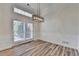 Dining room with modern light fixture, large window, and beautiful hardwood floors at 3535 Southmont Ct, Cumming, GA 30041