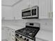 Close up of stainless steel stove and microwave set in white cabinetry at 3535 Southmont Ct, Cumming, GA 30041