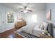 Staged bedroom featuring a ceiling fan, two windows for natural light, and hardwood floors at 610 Walnut Sw Pl, Marietta, GA 30060