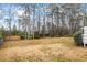 A large backyard featuring many trees and a partial fence line at 334 Nancy Sw Ct, Lilburn, GA 30047