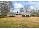 A back exterior view of home with a spacious yard and screened porch at 334 Nancy Sw Ct, Lilburn, GA 30047