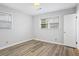 A minimalist bedroom with light gray walls and modern laminate flooring at 334 Nancy Sw Ct, Lilburn, GA 30047