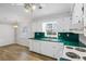 Bright kitchen featuring white cabinets, laminate countertops, updated fixtures, and wood-look flooring at 334 Nancy Sw Ct, Lilburn, GA 30047