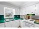 Classic kitchen featuring white cabinets, green countertops, laminate floors, and stainless-steel sink at 334 Nancy Sw Ct, Lilburn, GA 30047