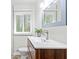 Bathroom with a wood vanity, modern mirror, white counters, and window providing natural light at 801 N Evelyn Nw, Atlanta, GA 30318