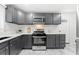 Stylish kitchen features grey cabinets, stainless steel appliances and white marble-patterned flooring at 801 N Evelyn Nw, Atlanta, GA 30318