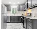 This kitchen features gray cabinets, white counter tops, stainless appliances and marble-patterned floors at 801 N Evelyn Nw, Atlanta, GA 30318