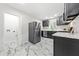 White kitchen features stainless steel refrigerator, gray cabinets, and marble patterned flooring at 801 N Evelyn Nw, Atlanta, GA 30318