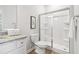 Bathroom with granite countertop vanity, white cabinets, framed art, and a glass-enclosed shower at 11837 Rizvan Pl, Covington, GA 30014