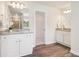 Bright bathroom featuring a double sink vanity with granite countertops and wood-look flooring at 11837 Rizvan Pl, Covington, GA 30014