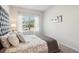 Bedroom with a large window, a tufted headboard, and a soft grey and white color scheme at 11837 Rizvan Pl, Covington, GA 30014