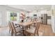 Dining area with a table, chairs, open to a kitchen featuring stainless steel appliances and white cabinetry at 11837 Rizvan Pl, Covington, GA 30014