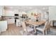 Dining area with a table, chairs, open to a kitchen featuring stainless steel appliances and white cabinetry at 11837 Rizvan Pl, Covington, GA 30014