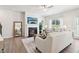 Bright living room with modern fireplace, neutral tones, wood flooring, and natural light streaming through windows at 11837 Rizvan Pl, Covington, GA 30014