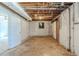 Unfinished basement with open ceiling, white painted brick walls and concrete floors at 6050 Randy Ln, Ellenwood, GA 30294