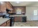 Traditional kitchen featuring wood cabinets, black appliances, and a granite countertop at 6050 Randy Ln, Ellenwood, GA 30294