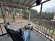 Cozy screened porch with rocking chair and view of the fenced backyard and greenery at 1672 Cedar Bluff Way, Marietta, GA 30062