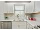 Well-lit kitchen with stainless steel appliances, white cabinets, and white tile backsplash at 2376 Wellington Cir, Lithonia, GA 30058