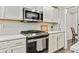 Modern kitchen features stainless steel oven and microwave with white cabinets at 2376 Wellington Cir, Lithonia, GA 30058