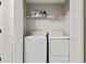 Efficient laundry room with a washer, dryer, and overhead storage shelf at 2376 Wellington Cir, Lithonia, GA 30058