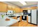 Bright kitchen with white countertops, appliances, and wood cabinetry, creating a functional cooking space at 1029 Daventry Xing, Woodstock, GA 30188