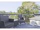 Outdoor patio with two wicker chairs and a table overlooking lush green trees and neighborhood views at 179 South Se Ave, Atlanta, GA 30315