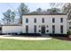 Stunning two-story home with white painted brick, black trim, and a lush green lawn at 3034 Farmington Se Dr, Atlanta, GA 30339