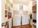 Efficient laundry room with a washer, dryer, built-in shelves, and colorful wall art at 3034 Farmington Se Dr, Atlanta, GA 30339