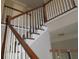 Staircase with a wood railing and white balusters leads to the upper level of the home at 3975 Broadleaf Walk, Ellenwood, GA 30294