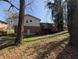 The backyard features a deck and mature trees on a sunny day at 8271 Walnut Dr, Jonesboro, GA 30238