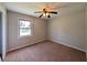 Neutral bedroom features a ceiling fan and window providing natural light at 8271 Walnut Dr, Jonesboro, GA 30238