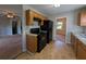 Efficient kitchen with wood cabinets, black appliances, and durable tile flooring at 8271 Walnut Dr, Jonesboro, GA 30238