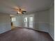 Cozy living room with ceiling fan, carpet flooring and access to outdoor deck at 8271 Walnut Dr, Jonesboro, GA 30238