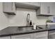 Stainless steel kitchen sink with chrome faucet, subway tile backsplash, and gray countertops at 9 Ivy Gates Ne, Atlanta, GA 30342