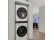 New, stacked white washer and dryer units tucked in a closet with views to living space at 9 Ivy Gates Ne, Atlanta, GA 30342