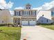 Charming two-story home with a brick facade and a two-car garage, set against a bright blue sky at 11108 Suria Dr, Covington, GA 30014