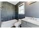 Beautifully updated bathroom with gray wall, marble counters and tiled shower over tub at 2125 Burnside Nw Dr, Atlanta, GA 30318