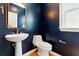 Stylish powder room with navy blue walls, pedestal sink, and elegant gold mirror at 2125 Burnside Nw Dr, Atlanta, GA 30318