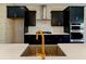 Modern kitchen featuring black cabinets, stylish backsplash, stainless steel appliances, and quartz countertops at 2125 Burnside Nw Dr, Atlanta, GA 30318