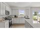 Bright kitchen with white cabinetry, stainless appliances, granite counters, and a center island at 2493 Cotton Ln, Douglasville, GA 30135