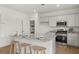 Bright kitchen with white cabinetry, stainless appliances, granite counters, and a center island with seating at 2493 Cotton Ln, Douglasville, GA 30135
