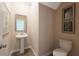 Charming powder room with a pedestal sink, elegant mirror, and tasteful wall art at 2493 Cotton Ln, Douglasville, GA 30135