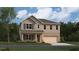Charming two-story home featuring a brick and siding facade, a covered porch, and an attached two-car garage at 2493 Cotton Ln, Douglasville, GA 30135