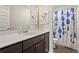 Bright bathroom offers vanity area with sink and a shower with a stylish patterned curtain at 305 Norwood Ne Ave, Atlanta, GA 30317