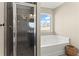 Bathroom features walk-in shower, bathtub, and window allowing natural light to brighten the space at 305 Norwood Ne Ave, Atlanta, GA 30317