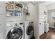 Bright laundry room with washer, dryer, storage shelves, and a door to a separate area at 305 Norwood Ne Ave, Atlanta, GA 30317