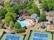 Aerial view highlighting community pool and tennis courts, nestled among trees at 6165 Lake Oak Lndg, Cumming, GA 30040